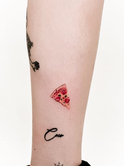Indulge in savory micro-realism by Carolina Feodorov with this intricately detailed pizza slice tattoo.