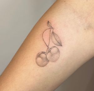 Get mesmerized by Alina Wiltshire's micro-realism technique in this stunning cherry design created through intricate dotwork and hand poke method.