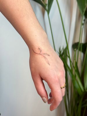 Unique dotwork and hand-poked tattoo by Alina Wiltshire, featuring a delicate vine and leaf motif. Perfect for nature lovers.