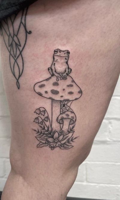 Unique hand-poked design by Marketa.handpoke, featuring a charming frog and intricate mushroom in dotwork and fine line style.