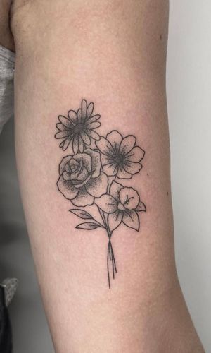 Experience the beauty of hand-poked dotwork in this intricate floral design by artist Marketa. Fine lines and detailed shading make this tattoo a stunning work of art.