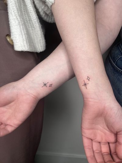 Experience the beauty of a hand-poked delicate star tattoo by Marketa, featuring intricate fine line work.