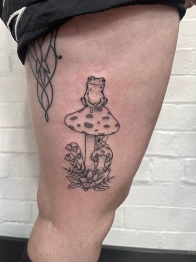 Hand-poked masterpiece by Marketa.handpoke combining intricate dotwork design with a charming frog and mushroom motif.
