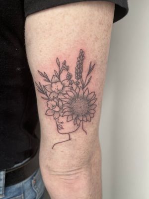 Embrace nature's beauty with this unique hand-poked dotwork tattoo featuring a sunflower woman design by Marketa.handpoke.