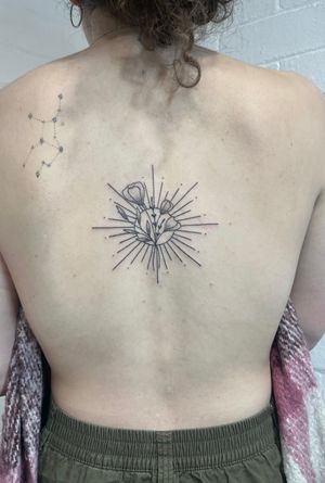Experience the beauty of nature with this intricate dotwork and fine line hand-poked tattoo of a sunflower. By talented artist Marketa.handpoke.