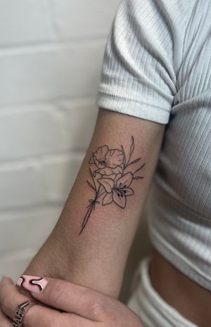 Elegant fine line flower tattoo created by Marketa.handpoke, perfect for a minimalist and timeless look.