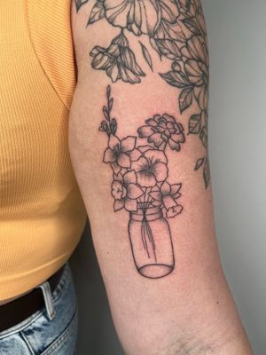 Beautiful hand-poke tattoo featuring a delicate flower in a jar, created by Marketa.handpoke. Perfect for nature lovers.