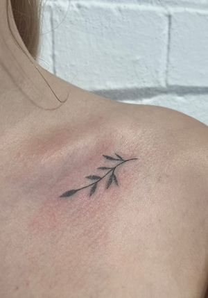 Unique hand-poked dotwork tattoo of a delicate branch by Marketa.handpoke, perfect for a minimalist and natural look.