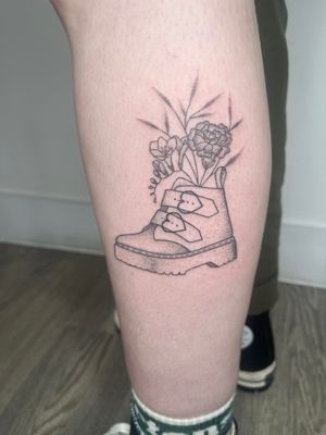 Unique dotwork hand-poked tattoo featuring a detailed flower design on a shoe or boot, by Marketa.handpoke.