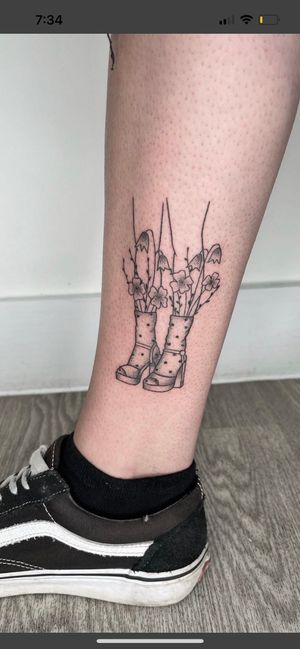 Elegant hand-poked tattoo featuring detailed dotwork flower design on feet, created by talented artist Marketa.