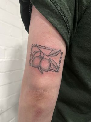Unique dotwork hand-poked tattoo featuring a stamp design with a lemon motif, created by the talented Marketa.handpoke.
