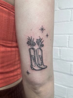 Unique hand-poked tattoo by Marketa, blending intricate dotwork with stylized floral and boot motifs. Stand out with this detailed and artistic piece.