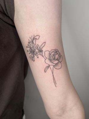 Elegant hand-poked tattoo by Marketa.handpoke featuring a delicate flower design in intricate dotwork and fine line style.