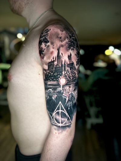 Capture the magic of Harry Potter with this stunning black and gray realism tattoo of Hogwarts Castle by the talented artist Alex Santo.