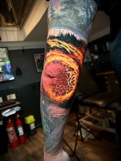 Experience the fiery intensity of the cosmos in this stunning realism and surrealism tattoo masterpiece by Alex Santo.