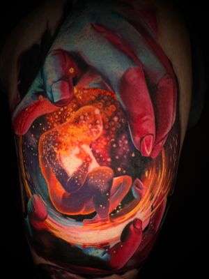 Witness the breathtaking fusion of realism and surrealism in this tattoo by Alex Santo, featuring human hands bringing life to creation.