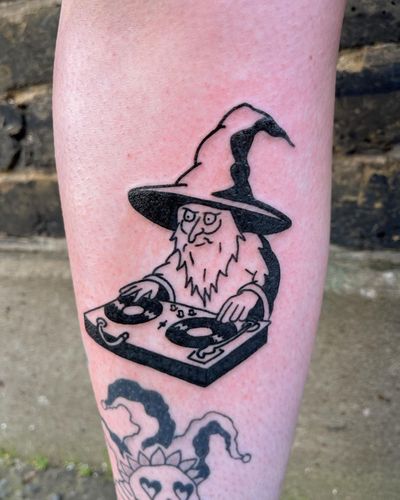 Get enchanted with this illustrative and ignorant wizard DJ tattoo by artist Dave Norman. Let the magic of music and sorcery come alive on your skin!