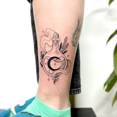 Illustrative tattoo by Michelle Harrison featuring a mystical moon and potion bottle design.