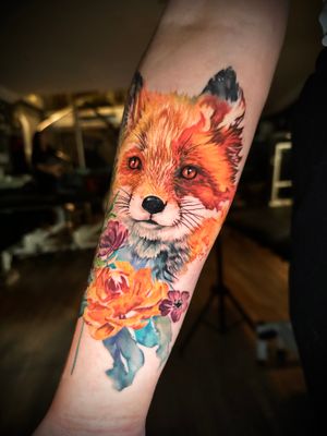 Get a stunning watercolor tattoo of a fox and flower by the talented artist Alex Santo. Add some color to your skin with this unique design.