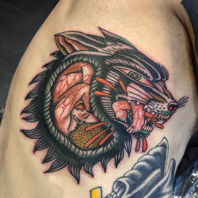 Capture the power and mystique of the wolf with this stunning traditional tattoo by renowned artist Benji Charnock.