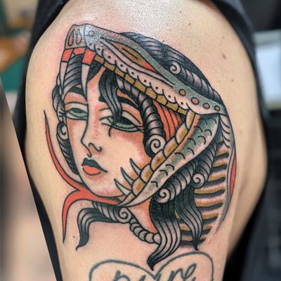 Captivating traditional tattoo featuring a snake intertwining with a woman, expertly inked by Benji Charnock.