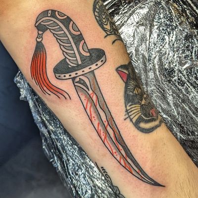 Get inked with a classic dagger design expertly executed by the talented artist Benji Charnock in traditional style.