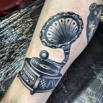 Experience the nostalgia of traditional music with this illustrative tattoo by Benji Charnock. Perfect for the music enthusiast!