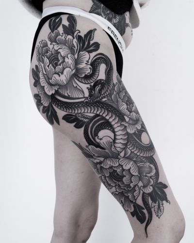 Illustrative tattoo featuring a striking snake entwined with delicate chrysanthemum flowers, created by talented artist Lukey Wolf.