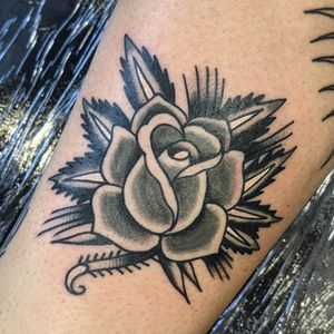 Get a timeless and vibrant traditional rose tattoo by the talented artist Benji Charnock. Perfect for lovers of classic tattoo art.