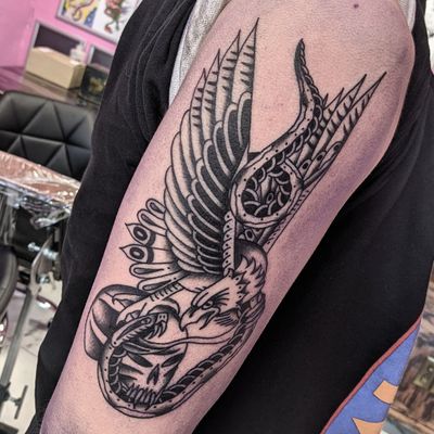 Unique traditional tattoo featuring a snake and eagle design by artist Benji Charnock.