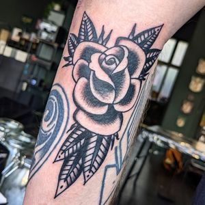Get bold and timeless with a traditional rose design inked by the talented Benji Charnock. Perfect for those who appreciate classic tattoo art.
