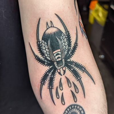 Get a classic spider design with bold outlines and vibrant colors by the talented artist Benji Charnock.