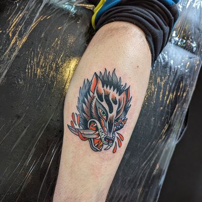 Embrace the wild with this classic traditional wolf tattoo, expertly inked by Benji Charnock. Let your inner spirit shine with this timeless design.