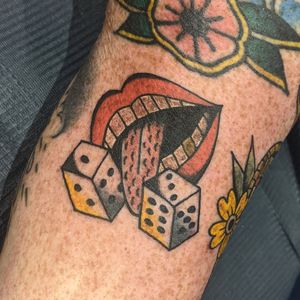 Get lucky with this classic traditional tattoo featuring dice and lips, done by the talented Benji Charnock.
