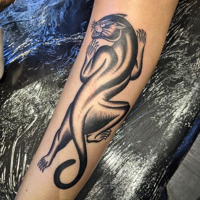 Get the fierce and timeless look with this traditional panther tattoo by renowned artist Benji Charnock. Perfect for those who seek strength and power in their ink.