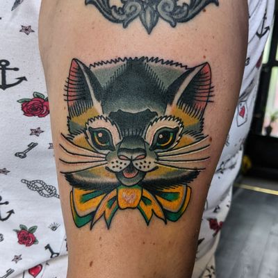 Experience the timeless art of traditional tattoos with this charming cat design by the talented artist, Benji Charnock.