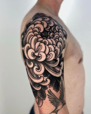 Get a beautiful illustrative chrysanthemum flower tattoo done by the talented artist Lukey Wolf. Perfect for a unique and eye-catching design.