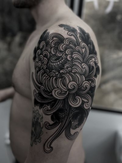 Experience the beauty of a detailed chrysanthemum tattoo with a unique illustrative style by renowned artist Lukey Wolf.