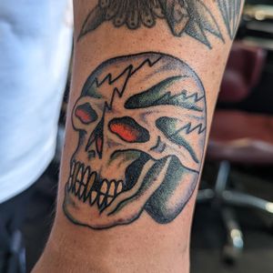 Get a bold and classic traditional skull tattoo by the talented artist Benji Charnock. A timeless design that will make a statement.