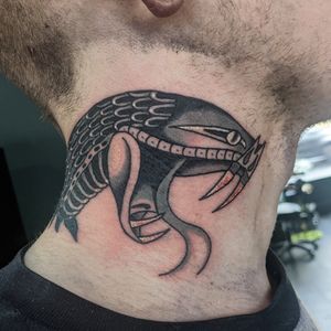 Lose yourself in the striking beauty of this traditional snake tattoo by talented artist Benji Charnock. Bold lines and vibrant colors bring this ancient symbol to life.