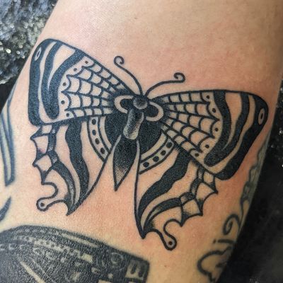 Get a stunning traditional butterfly tattoo by the talented artist Benji Charnock. Vibrant colors and intricate details to make it pop!