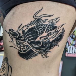 Experience the power and beauty of a classic traditional dragon tattoo done by the talented artist Benji Charnock.