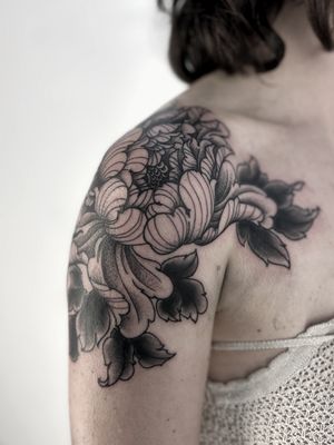 Experience the beauty of a floral masterpiece with this intricate peony tattoo by the talented artist, Lukey Wolf.
