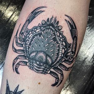 Get inked with a classic traditional crab design by the talented artist Benji Charnock. Embrace the power and resilience of the crab symbol in this timeless tattoo.