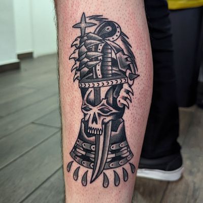 Get inked with a bold traditional tattoo featuring a dagger and hand by skilled artist Benji Charnock.