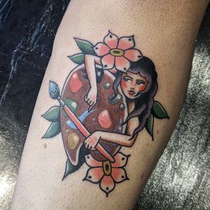Exquisite traditional tattoo by Benji Charnock featuring a beautiful woman painting a delicate flower. A timeless and colorful design.
