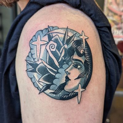 Capture the magic of the night sky with this stunning traditional tattoo design by Benji Charnock. Featuring a beautiful moon, delicate rose, and mysterious woman.