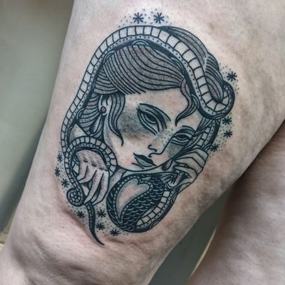 Experience the mesmerizing beauty of a traditional snake and woman tattoo by the talented artist Benji Charnock.