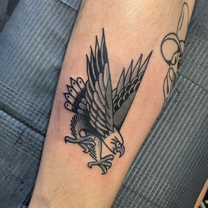 Get an iconic traditional eagle tattoo by the talented artist Benji Charnock. Bold and timeless design.
