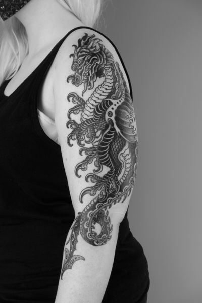 Get a fierce illustrative dragon tattoo with a medieval twist by renowned artist Lukey Wolf. Perfect for fans of mythical creatures!